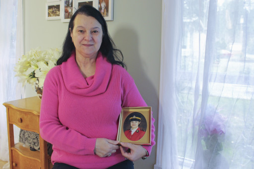 Alice Clark, pictured at home in Nanaimo, B.C., with her RCMP graduation photo from 1981.